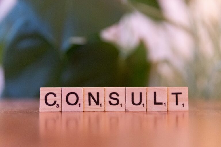 A wooden block spelling consulting on a table; benefits consultants